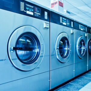 Interior of a contemporary launderette featuring advanced stainless steel washing machines.