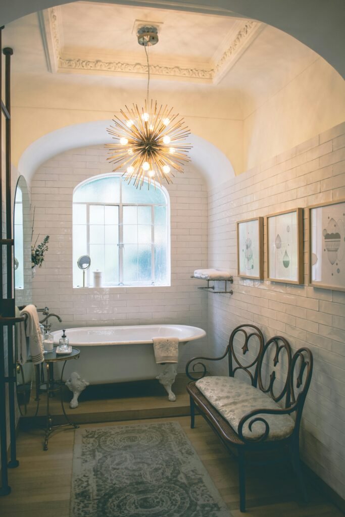 Charming vintage bathroom with a luxurious clawfoot tub and elegant chandelier lighting.