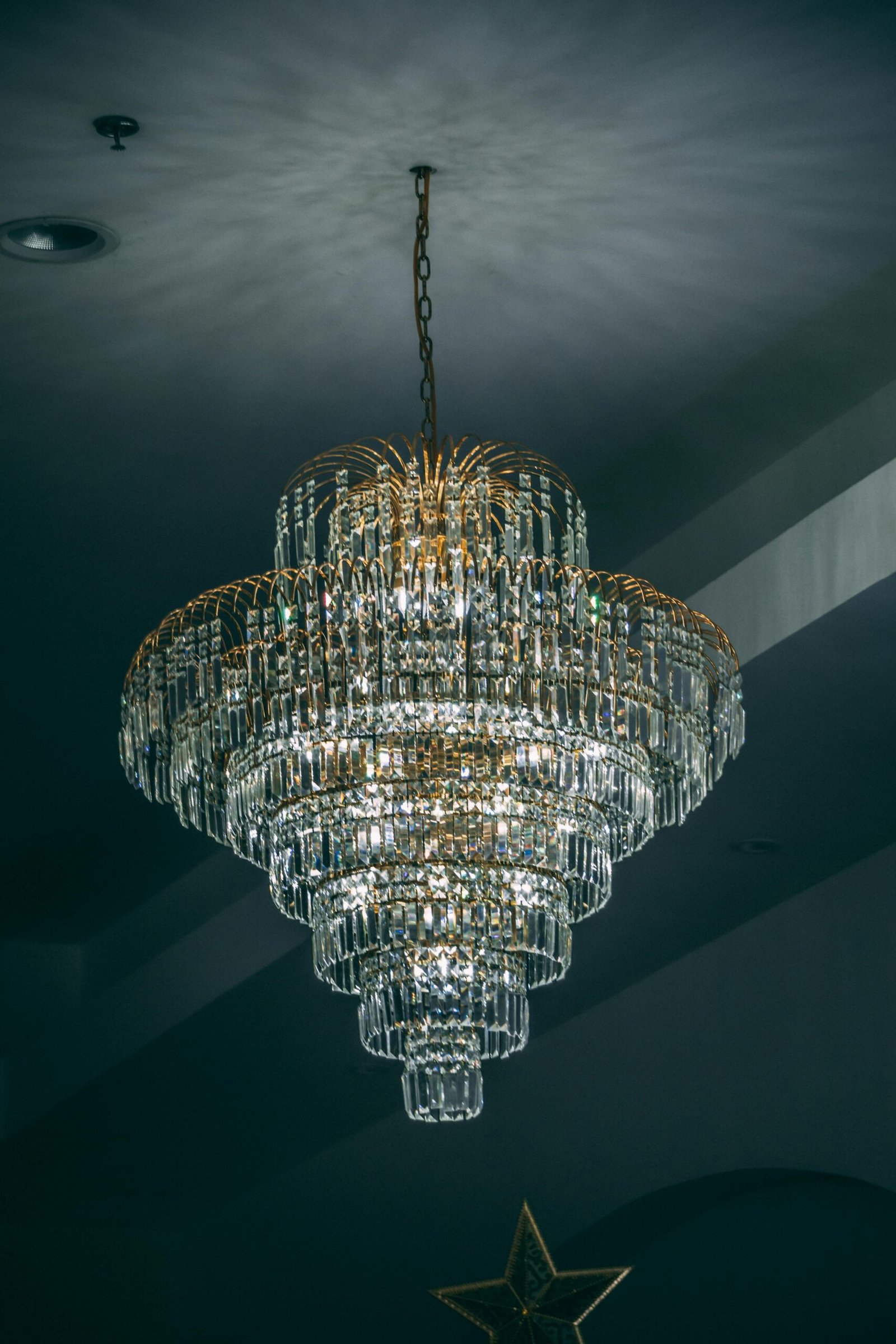 Glistening crystal chandelier hanging from a ceiling, highlighting classic interior design.