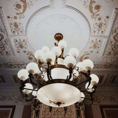 Classic chandelier and ornate ceiling design in an exquisite indoor setting.